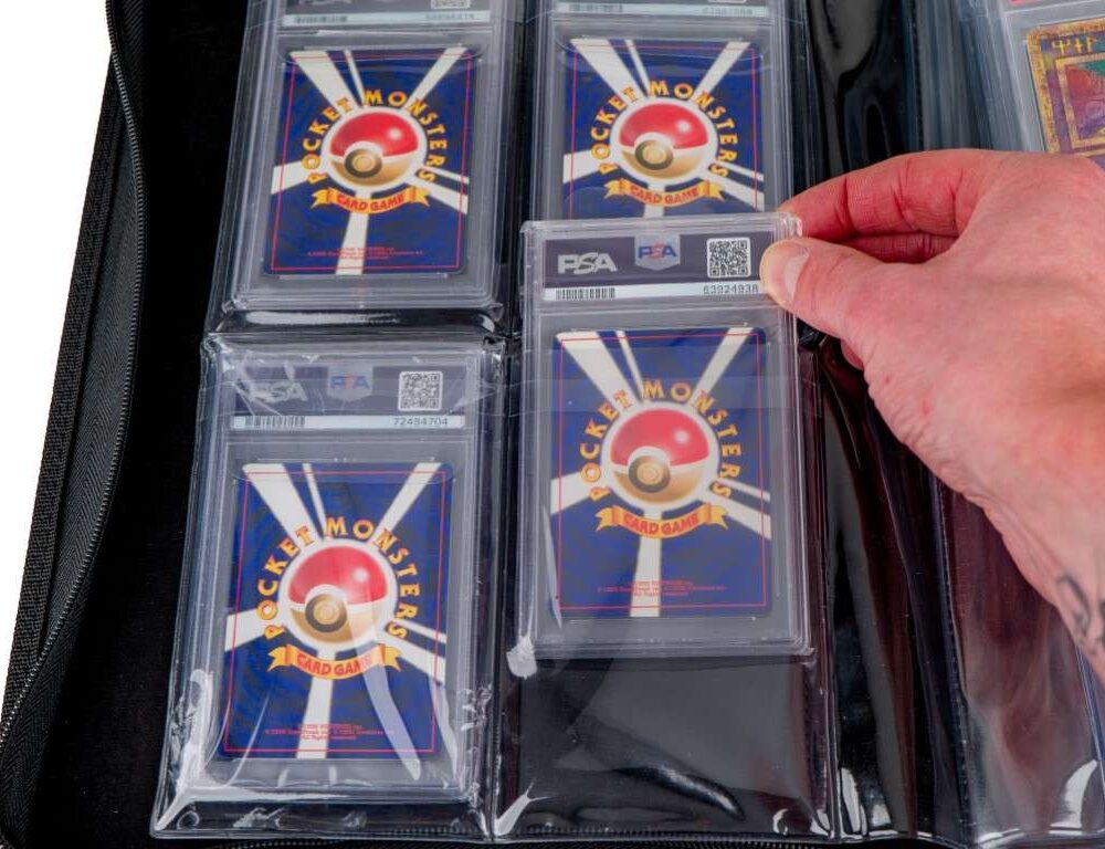 Hand placing PSA graded card into binder pocket